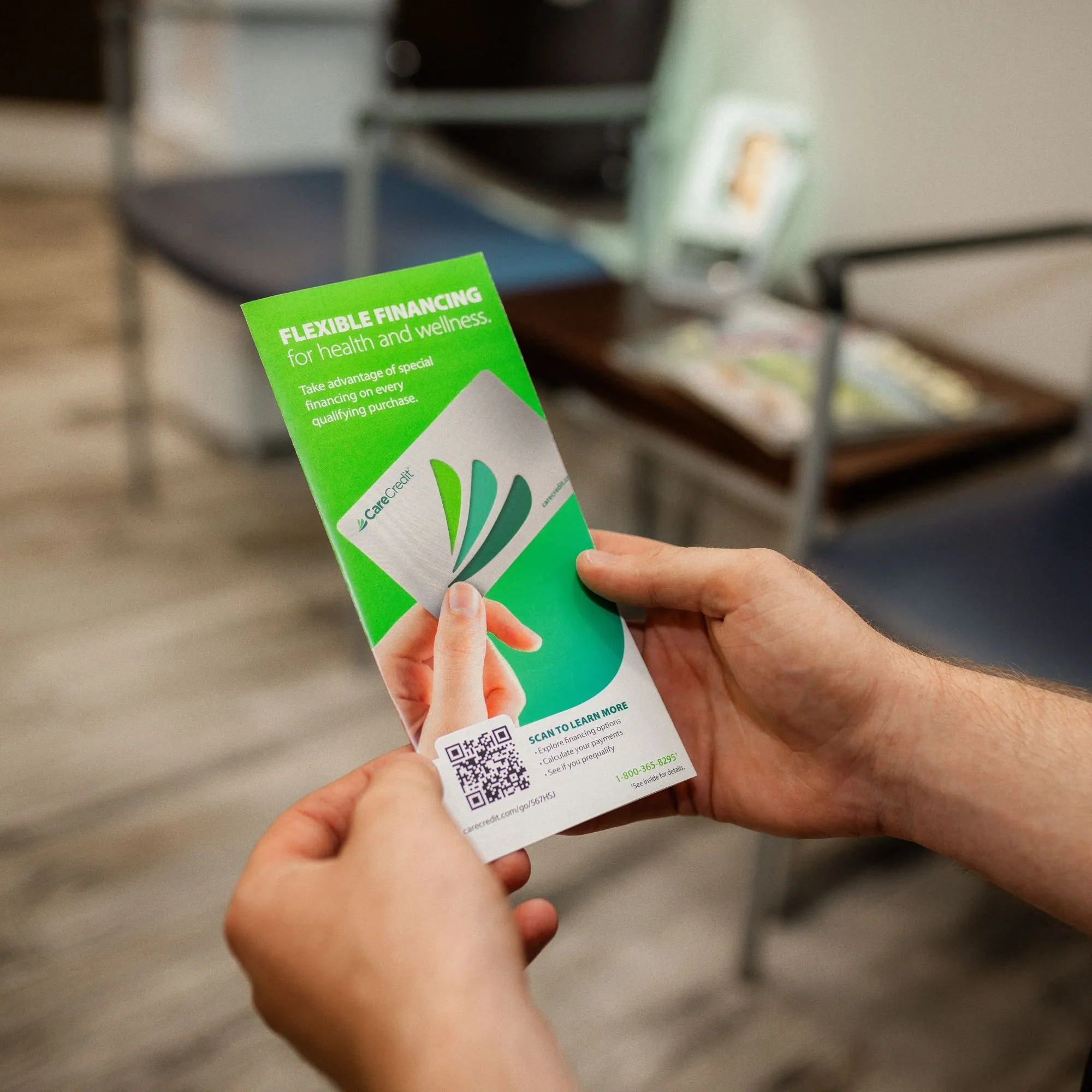 A patient holding a CareCredit 'Flexible Financing for health and wellness' brochure