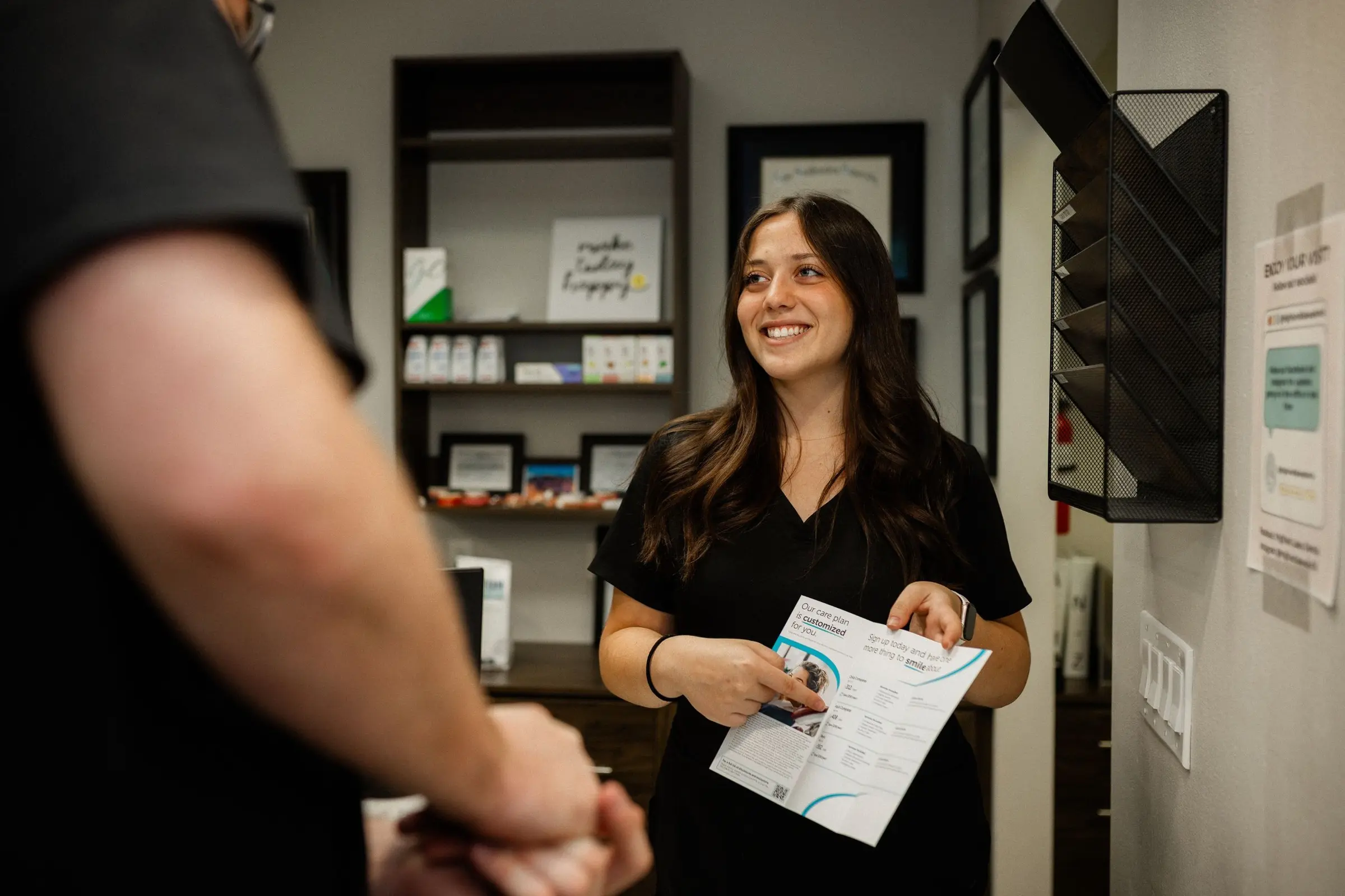 A Highland Lakes Dental team member walking a patient through the membership plan brochure